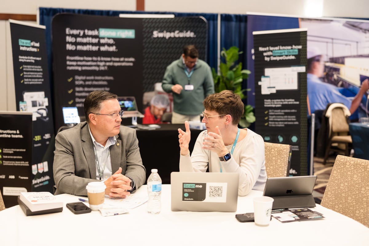 Solution provider sitting at a table meeting with a delegate at the 2024 American Manufacturing Summit